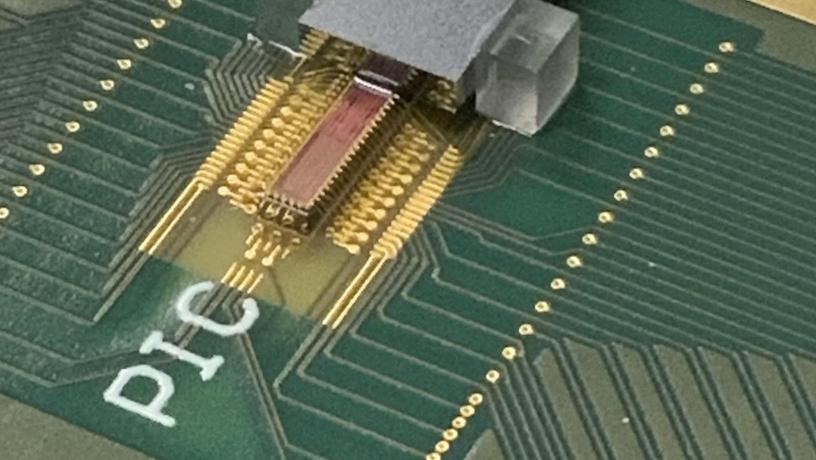 Photonic transmitter chip mounted on a printed circuit board with electrical and fiber optic connections