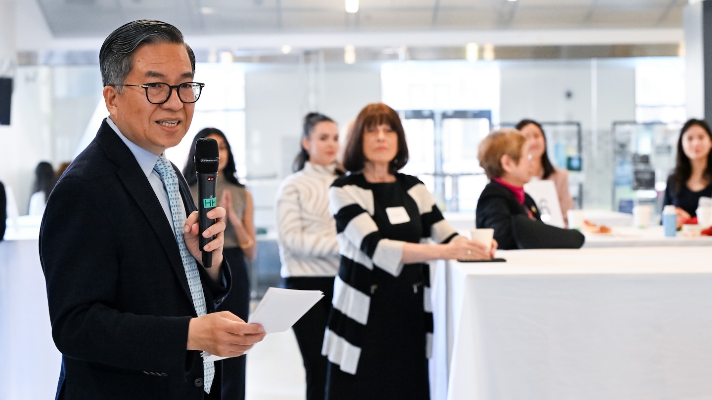 Columbia Engineering Dean Shih-Fu Chang holds a microphone among a room crowded with women