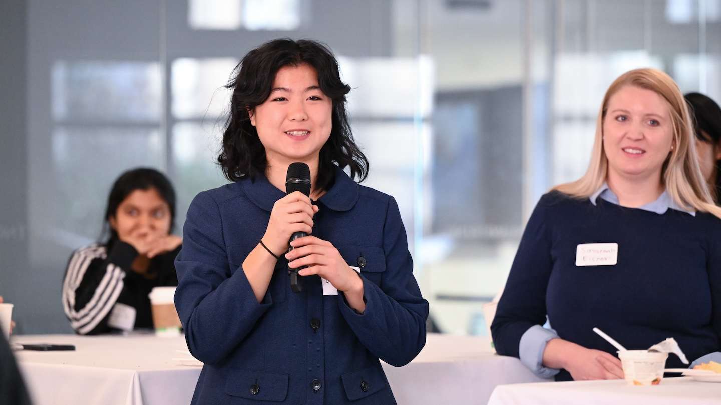 A woman holds a microphone