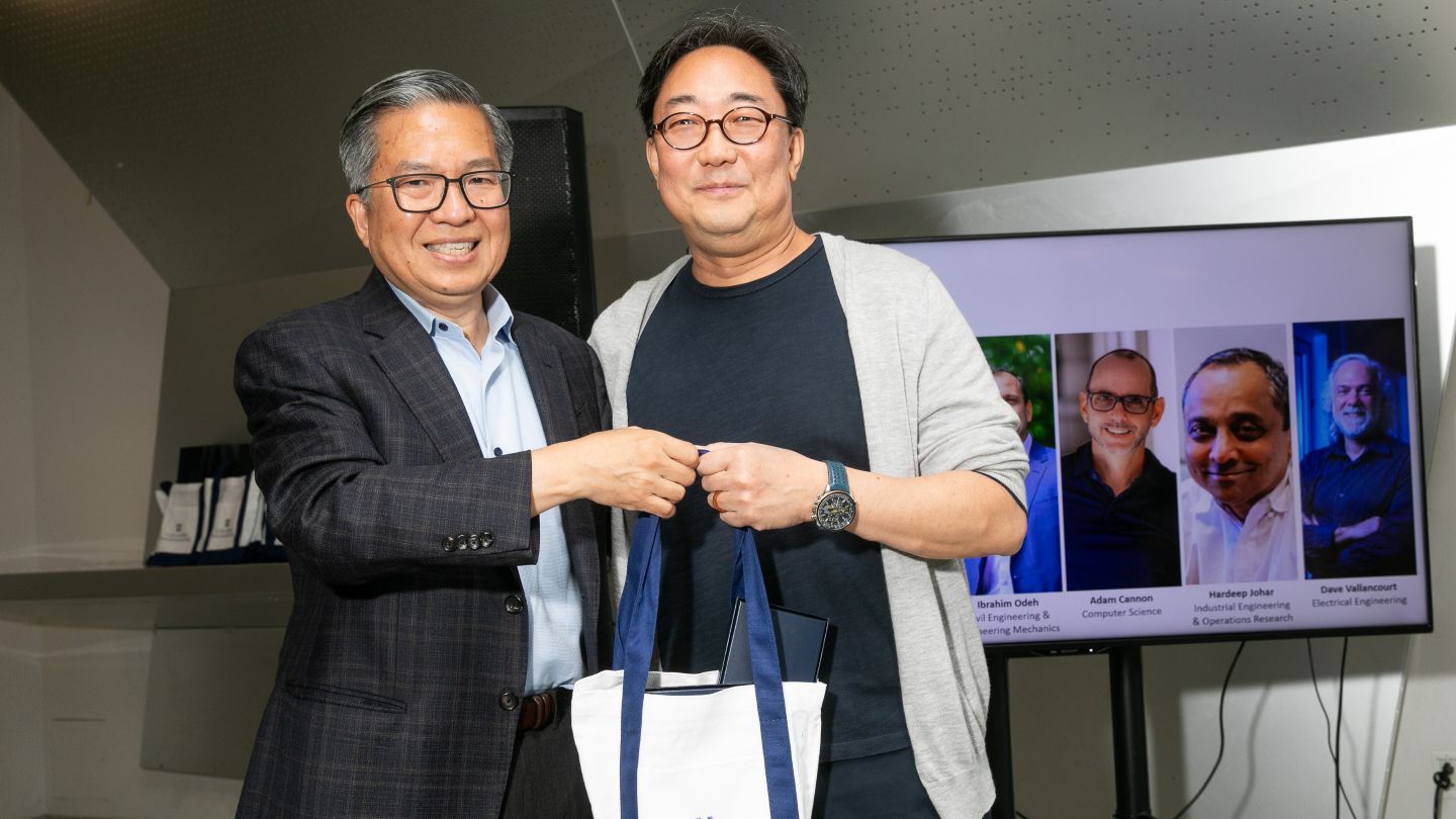 Jae Lee and Dean Shih-Fu Chang hold a tote bag together.