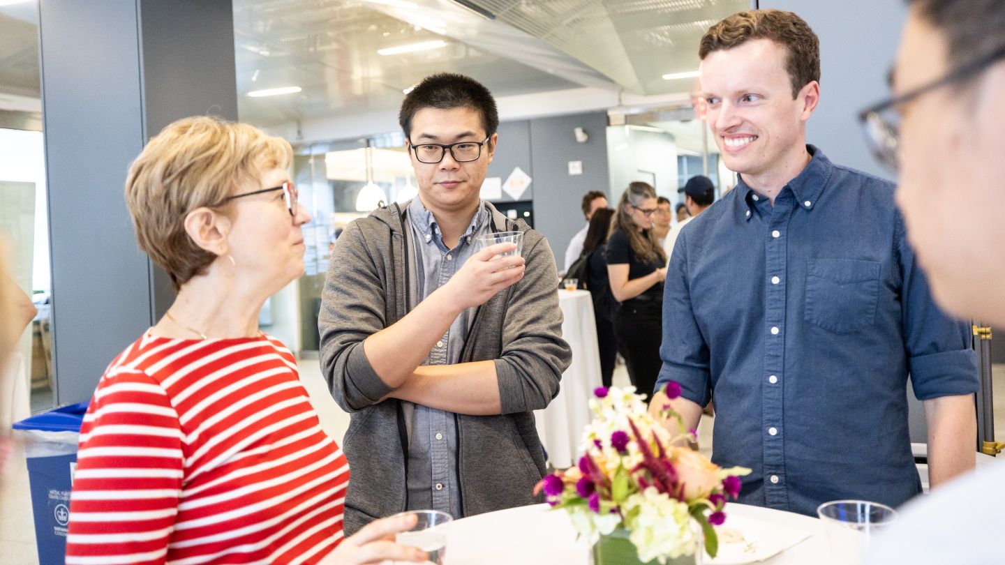 Applied Physics and Applied Mathematics faculty talk around a table at the Welcome Back Faculty and Honors event.